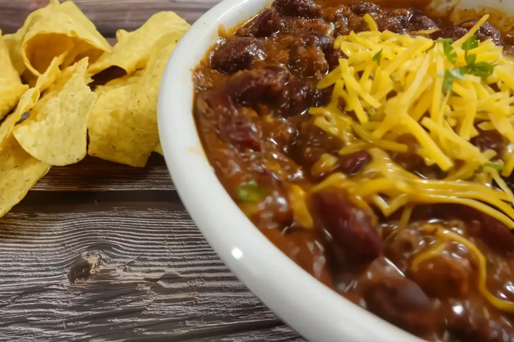 easy homemade chili recipe with cheddar cheese in white serving bowl