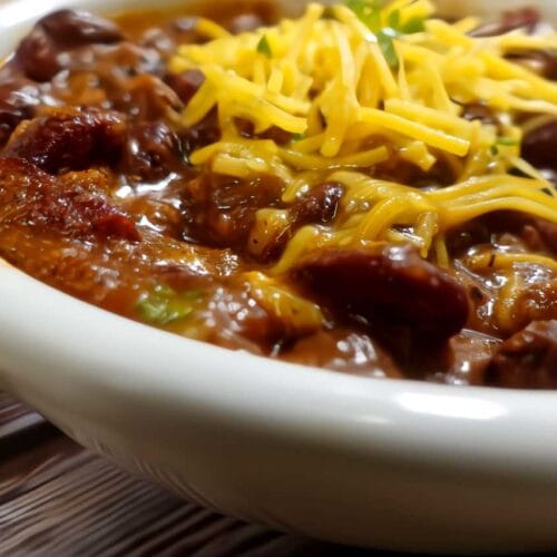 homemade chili recipe with shredded cheese on top