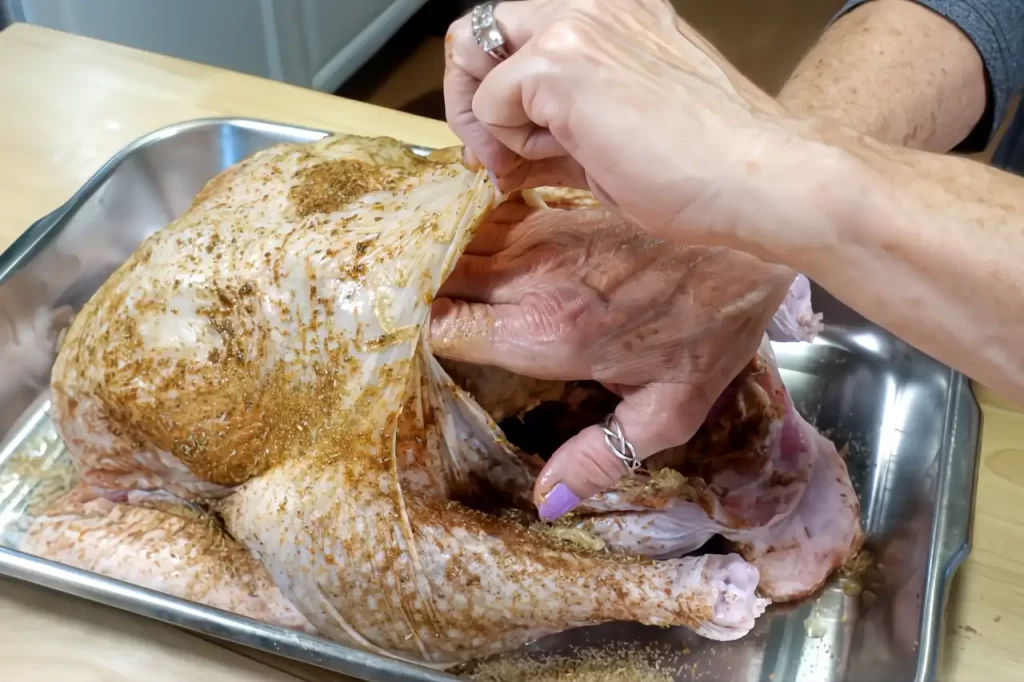 placing-herb-butter-under-breast-skin-on-turkey.