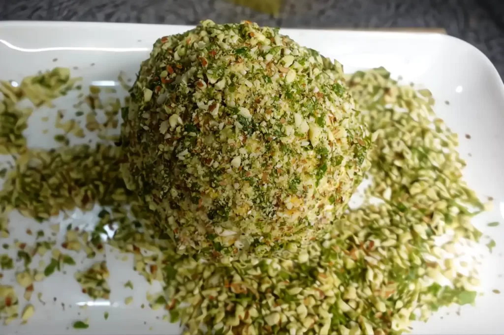 cheese-ball-being-rolled-in-herb-and-nuts.