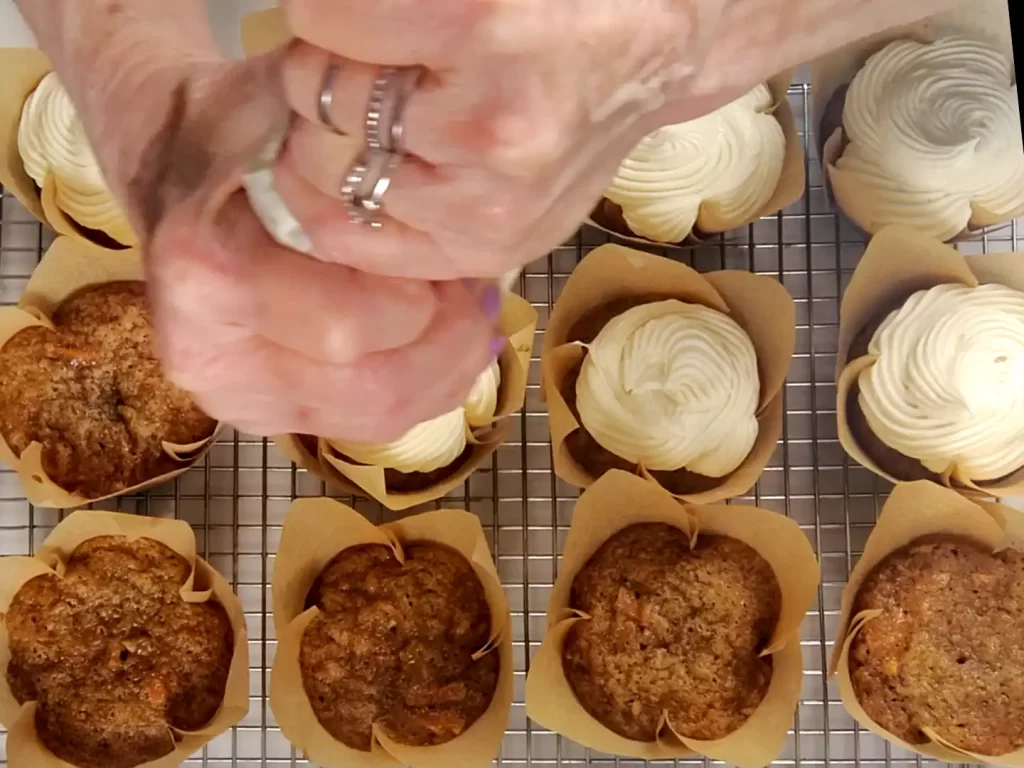 image-piping-cream-cheese-frosting-on-carrot-cupcake