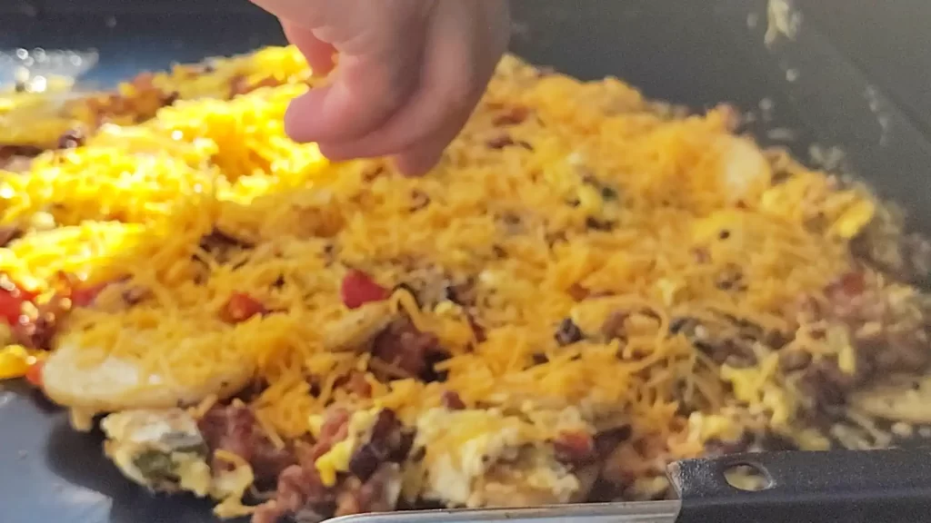 adding-cheese-to-breakfast-scramble