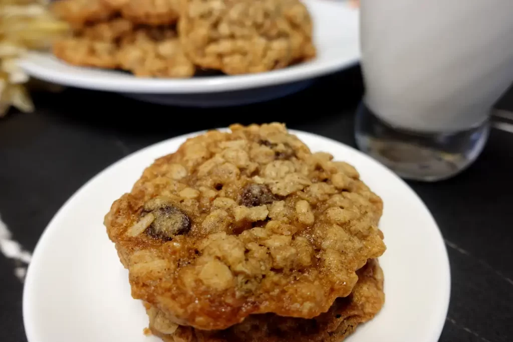 close-up-oatmeal-raisin-cookie-on-plate-with-glass-of-milk