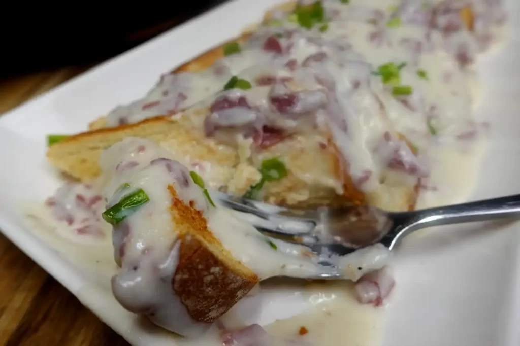 platter-of-creamed-dried-beef-with-fork-cutting-through-piece.