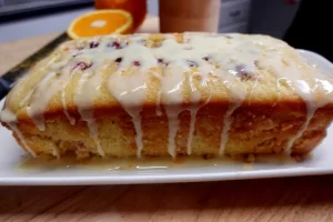 side-view-loaf-of-cranberry-orange-quickbread-with-glaze-dripping