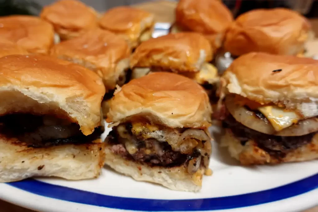close-up-of-onion-ring-smash-sliders-on-platte