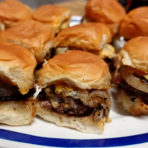 close-up-of-onion-ring-smash-sliders-on-platte
