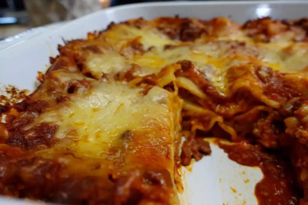 lasagna-in-white-baking-dish-with-piece-removed