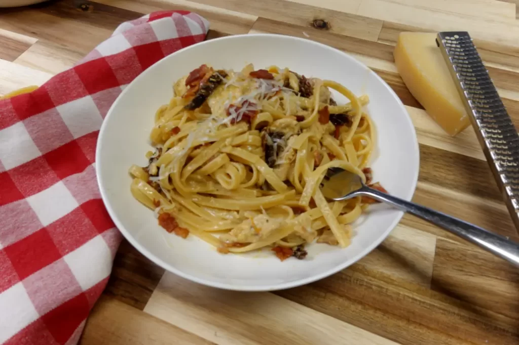 chicken-carbonaro-on-serving-plate-alongside-block-parmesan