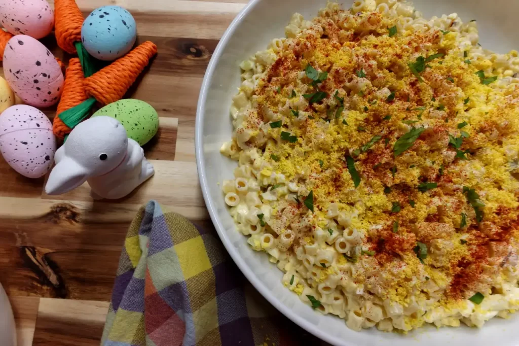 top-view-deviled-egg-pasta-salad-with-easter-decorations-beside-white-serving-bowl.webp