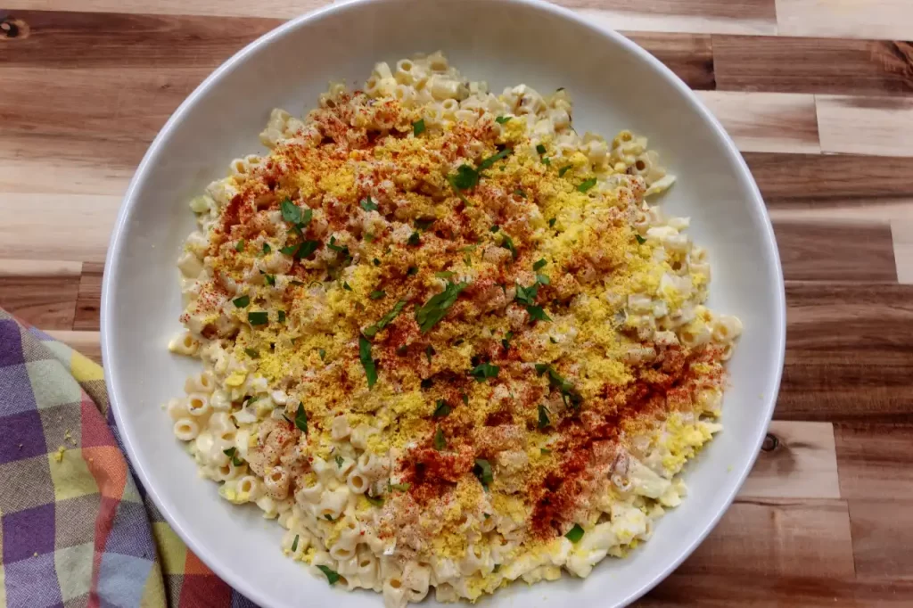 top-view-of-deviled-egg-pasta-salad-garnished-with-paprika-egg-yolk-and-parsley.webp