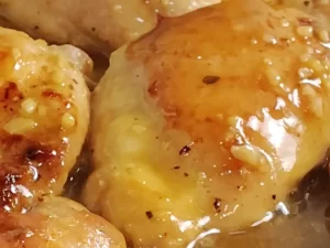 orange butter chicken in skillet shiny and glossy
