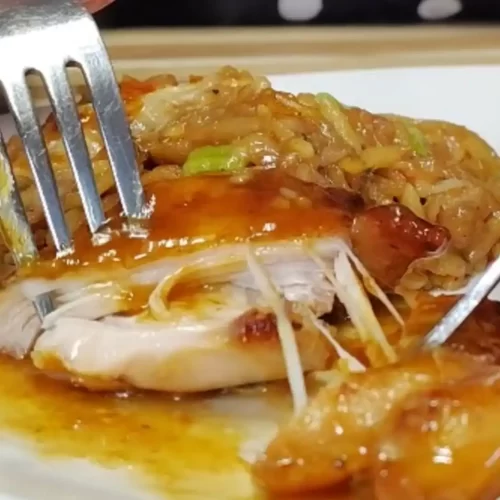 orange butter chicken close up meat being pulled apart