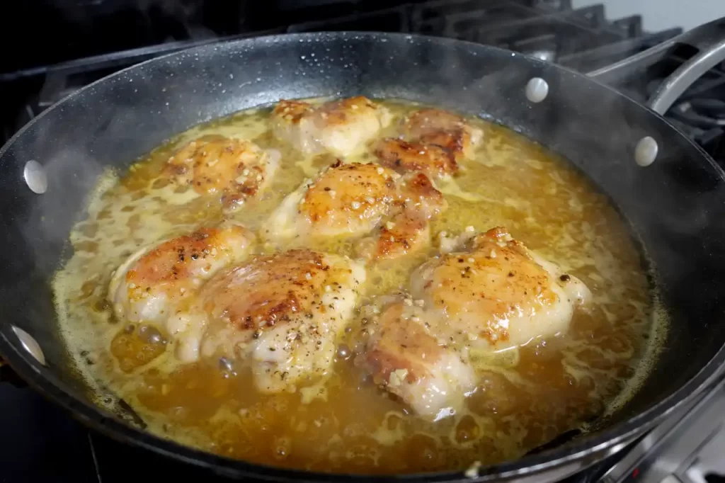 chicken-cooking-in-orange-butter-sauce