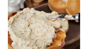 bagel-being-spread-with-veggie-cream-cheese-spread.