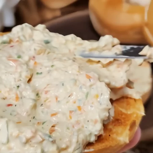 bagel-being-spread-with-veggie-cream-cheese-spread.