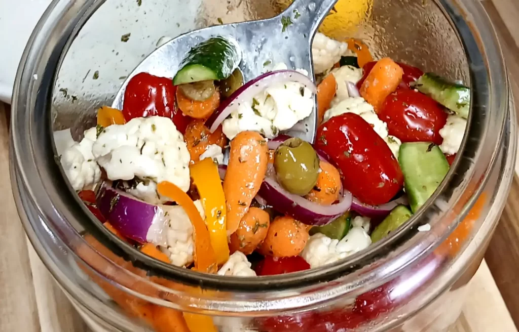 spoon-being-taken-out-of-jar-of-marinated-vegetables.