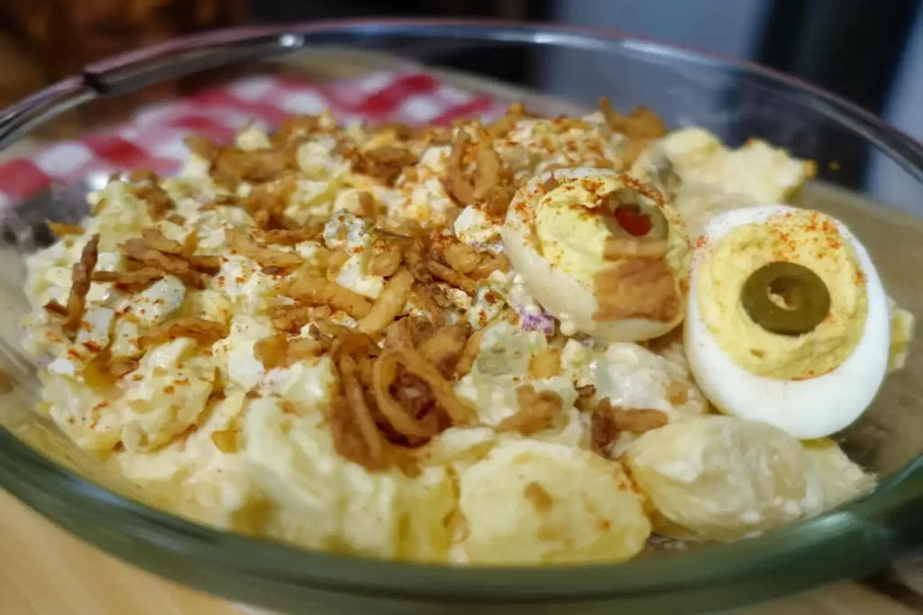 close-up-bowl-of-deviled-egg-potato-salad-with-2-deviled-eggs-on-top.