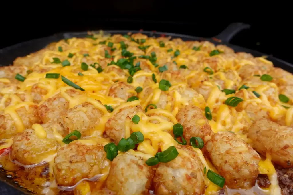 close-up-cowboy-tater-tot-skillet-with-crispy-tots-cheese-and-green-onion-topping
