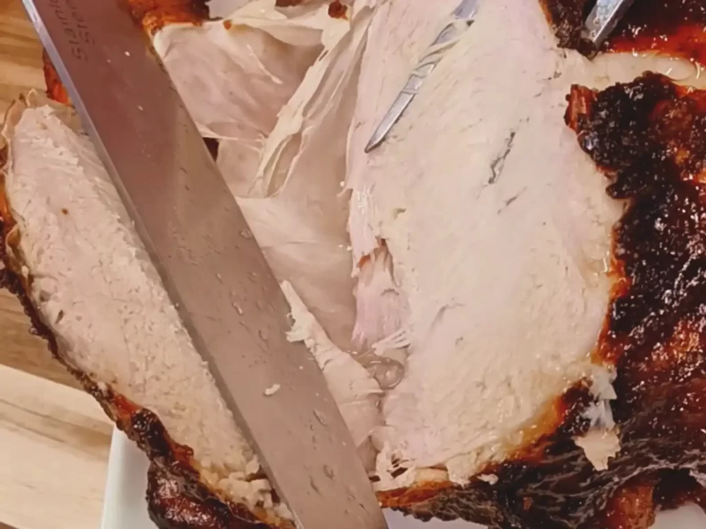 close-up-of-breast-being-carved-on-sweet-onion-ginger-beer-chicken
