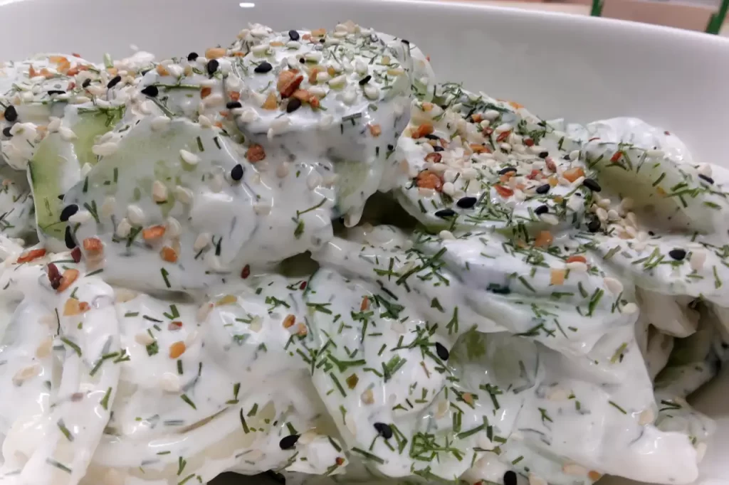 A-bowl-of-creamy-cucumber-onion-salad-made-with-fresh-cucumbers-sweet-onions-sour-cream-dill-and-topped-with-Everything-Bagel-seasoning.