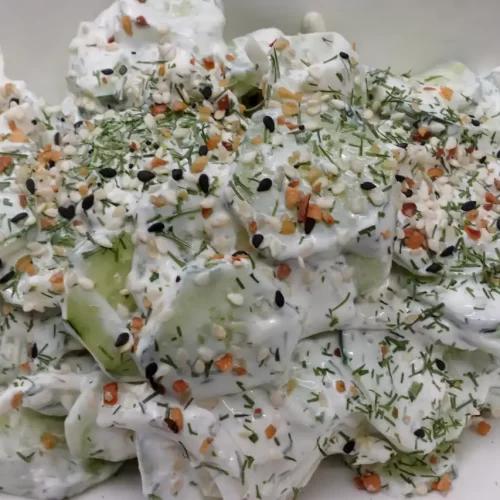 A-bowl-of-creamy-cucumber-onion-salad-made-with-fresh-cucumbers-sweet-onions-sour-cream-dill-sprinkled-with-Everything-Bagel-seasoning