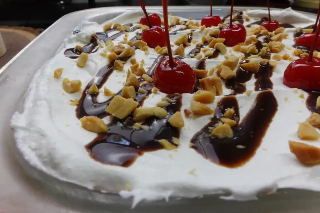 close-up-of-whipped-topping-chocolate-syrup-and-cherries-on-no-bake-banana-split-dessert