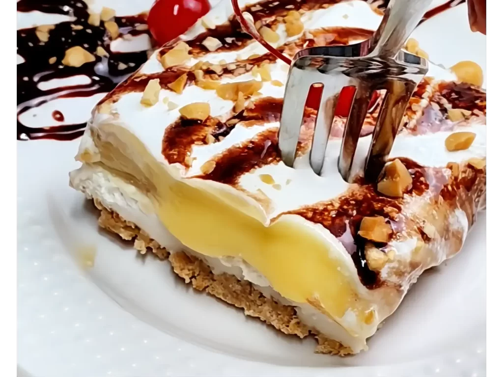 fork-cutting-into-serving-of-no-bake-banana-split-dessert