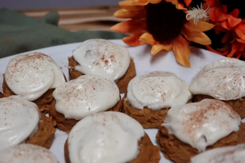 close-up-pumpkin-cookies-with-cream-cheese-frosting-on-platter.