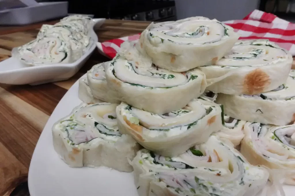 turkey-cucumber-pinwheels-side-view-on-wooden-table-with-red-white-checkered-cloth
