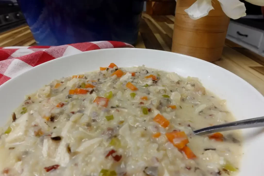 Bowl-of-creamy-chicken-and-wild-rice-soup-with-shredded-chicken-carrots-celery-and-parsley.