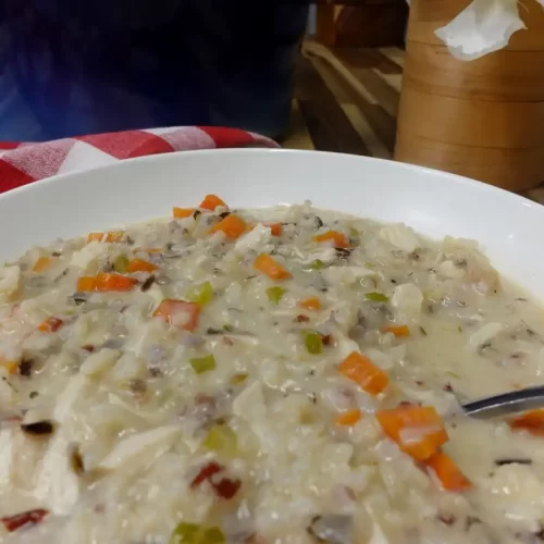 Bowl-of-creamy-chicken-and-wild-rice-soup-with-shredded-chicken-carrots-celery-and-parsley.
