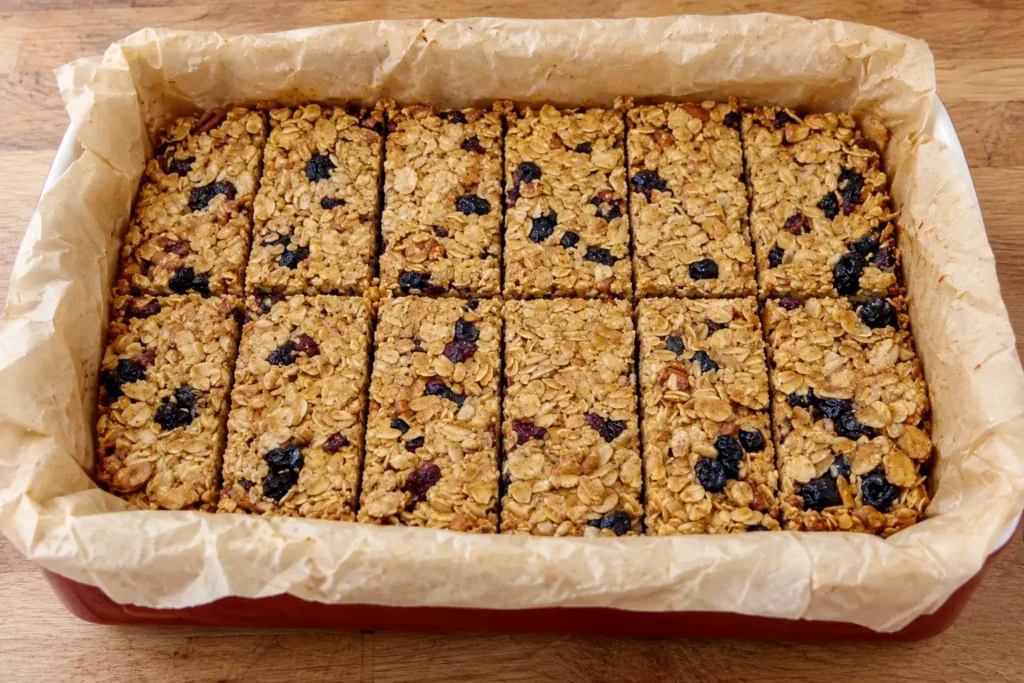 Homemade-Blueberry-Cranberry-Granola-Bars-in-a-parchment-lined-red-baking-dish
