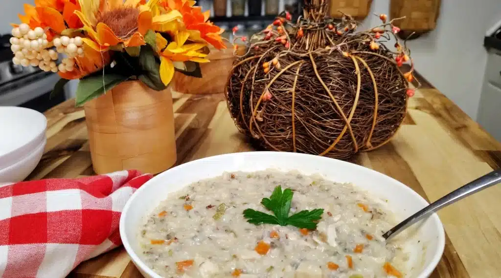 white-Bowl-of-creamy-chicken-and-wild-rice-soup-with-shredded-chicken-carrots-celery-and-parsley.